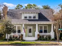 Charming one-story home featuring a cozy front porch with white columns and lovely landscaping at 3034 Carmello Ave, Orlando, FL 32814