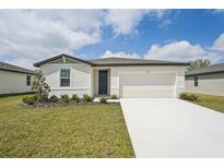 Charming single-story home with a well-manicured lawn and a two-car garage on a sunny day at 1337 Oak Valley Dr, Auburndale, FL 33823