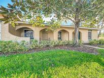 Inviting home exterior showcasing an arched portico, lush lawn, and mature landscaping creating curb appeal at 542 Cascade Cir # 102, Casselberry, FL 32707