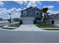 Charming two-story home showcasing a well-maintained lawn, a driveway, and a neatly attached two-car garage at 247 Villavista Ct, Davenport, FL 33896