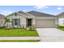 Charming single-story home with a well-manicured lawn, gray exterior, and a two-car garage at 1792 Aurora Oak Ln, Sanford, FL 32771