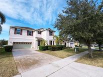 Charming two-story home with landscaped front yard, brick-paved driveway, and attached two car garage at 1208 Sawgrass Pointe Dr, Orlando, FL 32824