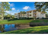 Two-story building with red tile roof and pond view at 3034 Parkway Blvd # 204, Kissimmee, FL 34747