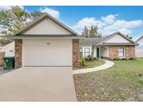 Brick ranch home with attached garage and landscaped yard at 1010 Cox Ct, Oviedo, FL 32765