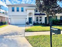 Two-story house with attached garage and landscaped yard at 10140 Cypress Vine Dr, Orlando, FL 32827