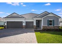 Charming single-story home boasts a three-car garage, paver driveway and stone accents at 2956 Arranmore Dr, Ormond Beach, FL 32174