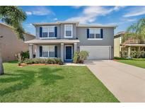 Charming two-story home with a well-manicured lawn, beautiful shrubbery, and a two car garage at 15443 Perdido Dr, Orlando, FL 32828