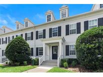 Charming townhouse with dormer windows, black shutters, manicured landscaping, and a welcoming entrance at 2097 Celebration Blvd, Celebration, FL 34747