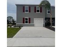 Charming two-story home featuring a well-kept lawn, gray exterior, red shutters, and a concrete driveway at 2729 Golden Trout Ln, Edgewater, FL 32141