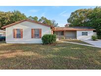 Ranch style home with brown shutters and a well-manicured lawn at 1748 Haverhill Dr, Deltona, FL 32725