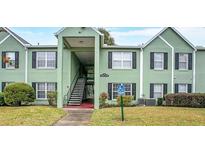 Inviting two-story condo with a handicap parking sign, black shutters, and well-maintained landscaping at 2053 Dixie Belle Dr # 2053C, Orlando, FL 32812