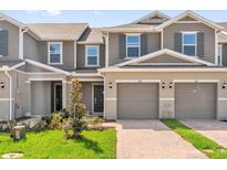 Charming townhome featuring a two-car garage, lush lawn, and a welcoming entrance at 367 Sequoia Dr, Lake Wales, FL 33859