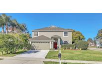 Charming two-story home with manicured lawn, mature landscaping, and a two-car garage at 497 Lakepark Trl, Oviedo, FL 32765