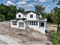New construction home showcasing a modern farmhouse design with white siding and a dark roof at 1309 Errol Green Ct, Apopka, FL 32712