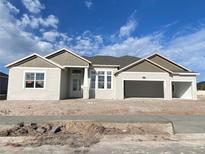 Charming single-story home featuring a two-car garage and stone accents on the facade, set against a beautiful sky at 2556 Hawks Overlook Pl, Oviedo, FL 32765