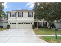 Two-story house with a two-car garage and well-maintained lawn at 555 Carey Way, Orlando, FL 32825