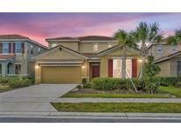 Two-story house with a large driveway and landscaping at 7833 Oak Reflection Loop, Davenport, FL 33837