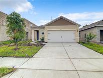 Newly constructed single-story home with a two-car garage and landscaped front yard at 791 Chinoy Rd, Davenport, FL 33837