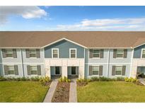 Two-story townhouses with gray siding, brown roofs and grassy yards at 826 Paradise Dr, Davenport, FL 33897