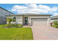 Charming single-story home with a well-manicured lawn, inviting brick driveway, and a two-car garage at 1124 Griffon Ave, Lake Alfred, FL 33850