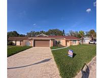 Charming single-story home featuring a well-manicured lawn, and a two car garage at 1859 Lake Hill Cir, Orlando, FL 32818