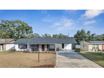 Charming single-story home featuring a brick facade, large windows, and a well-maintained front yard at 2509 Healy Dr, Orlando, FL 32818