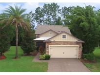 Charming home with a stone facade and a well-manicured lawn with mature landscaping at 513 San Sebastian Ct, Davenport, FL 33837