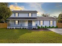 Charming two-story home with a welcoming front porch and well-manicured lawn at 805 Melody Dr, Chuluota, FL 32766
