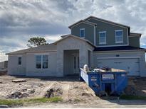 Two-story home featuring a two-car garage, covered porch, and a combination of stucco and siding at 987 Hawksnest Pt, Oviedo, FL 32765