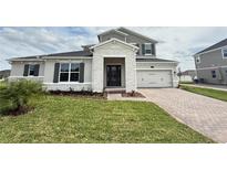 Charming two-story home with manicured lawn, stone accents, and a two-car garage at 987 Hawksnest Pt, Oviedo, FL 32765