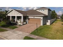 Charming two-story home featuring a brick driveway, two car garage, and well maintained lawn at 3811 Island Green Way, Orlando, FL 32824