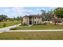 Two-story house with brick exterior, landscaping, and driveway at 465 Songbird Way, Apopka, FL 32712