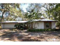 Ranch-style home with attached garage, nestled among mature trees at 2663 Magnolia Rd, Deland, FL 32720
