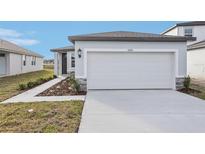 New construction home exterior featuring a two-car garage and walkway at 2522 Linda Knoll Ln, Bartow, FL 33830