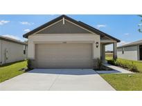 Home featuring an attached garage, concrete driveway, and manicured lawn at 2526 Linda Knoll Ln, Bartow, FL 33830