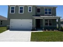 Charming two-story home boasts a large garage, well-manicured lawn, and inviting covered entryway at 3528 Sandalwood Isle Way, Ocoee, FL 34761