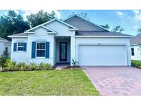Charming single-story home with brick paver driveway, blue shutters, and well-manicured lawn at 1664 Andover Ridge Dr, Deland, FL 32720