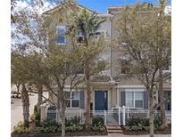 Tan three-story townhome with blue door, white fence, and landscaping at 751 Greybull Run, Lake Mary, FL 32746