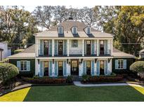 A charming two-story home with light blue shutters and manicured lawn at 1400 Place Picardy, Winter Park, FL 32789