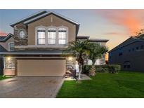 Two-story house with stone accents and a two-car garage at 2620 Sand Arbor Cir, Orlando, FL 32824
