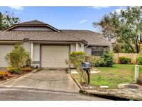 Tan house with brown roof, attached garage, and landscaping at 2682 Orange Peel Ct, Orlando, FL 32806