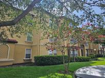 Tan building exterior with lush landscaping and trees at 5132 Conroy Rd # 932, Orlando, FL 32811