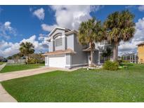 Charming two-story home features a well-manicured lawn, palm trees, and attached two-car garage at 3279 Fairfield Dr, Kissimmee, FL 34743