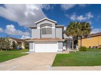 Charming two-story home with a well-manicured lawn, attached garage, and welcoming curb appeal at 3279 Fairfield Dr, Kissimmee, FL 34743
