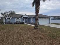 Charming single-Gathering home with a manicured lawn, two-car garage, and a beautifully designed entrance at 15613 Greater Groves Blvd, Clermont, FL 34714