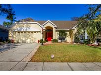 One-story house with red door, two-car garage, and well-manicured lawn at 1662 Canoe Creek Rd, Oviedo, FL 32766