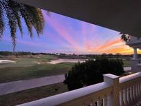 Stunning sunset over a golf course, viewed from a private balcony at 1364 Centre Court Ridge Dr # 201, Reunion, FL 34747