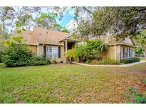 One-story house with tan siding, stone accents, and a landscaped lawn at 6408 Shoreline Ct, St Cloud, FL 34771