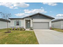 One-story home with gray siding, light stone accents, and a two-car garage at 2121 Rosewood Dr, Bartow, FL 33830