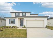Two-story house with gray door and white siding at 2137 Rosewood Dr, Bartow, FL 33830